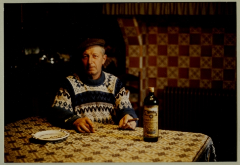 André Van Hecke met fles "Ouden Balegemsen" en sigaar, stokerij Van Damme, Balegem, ca. 1980