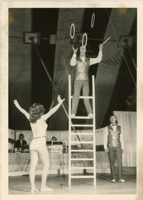 Jongleur met vier ringen op een ladder