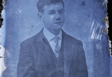 Zittend portret van jonge man in feestkledij bestaande uit kostuum en wit hemd met stropdas, kuifvormig opzij gekamd   haar, Melle , 1910-1920
