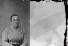 Zittend portret van vrouw in feestkledij, versierde bloes en korte halsketting, strak naar achter gekamd opgestoken haar, Melle, 1910-1920
